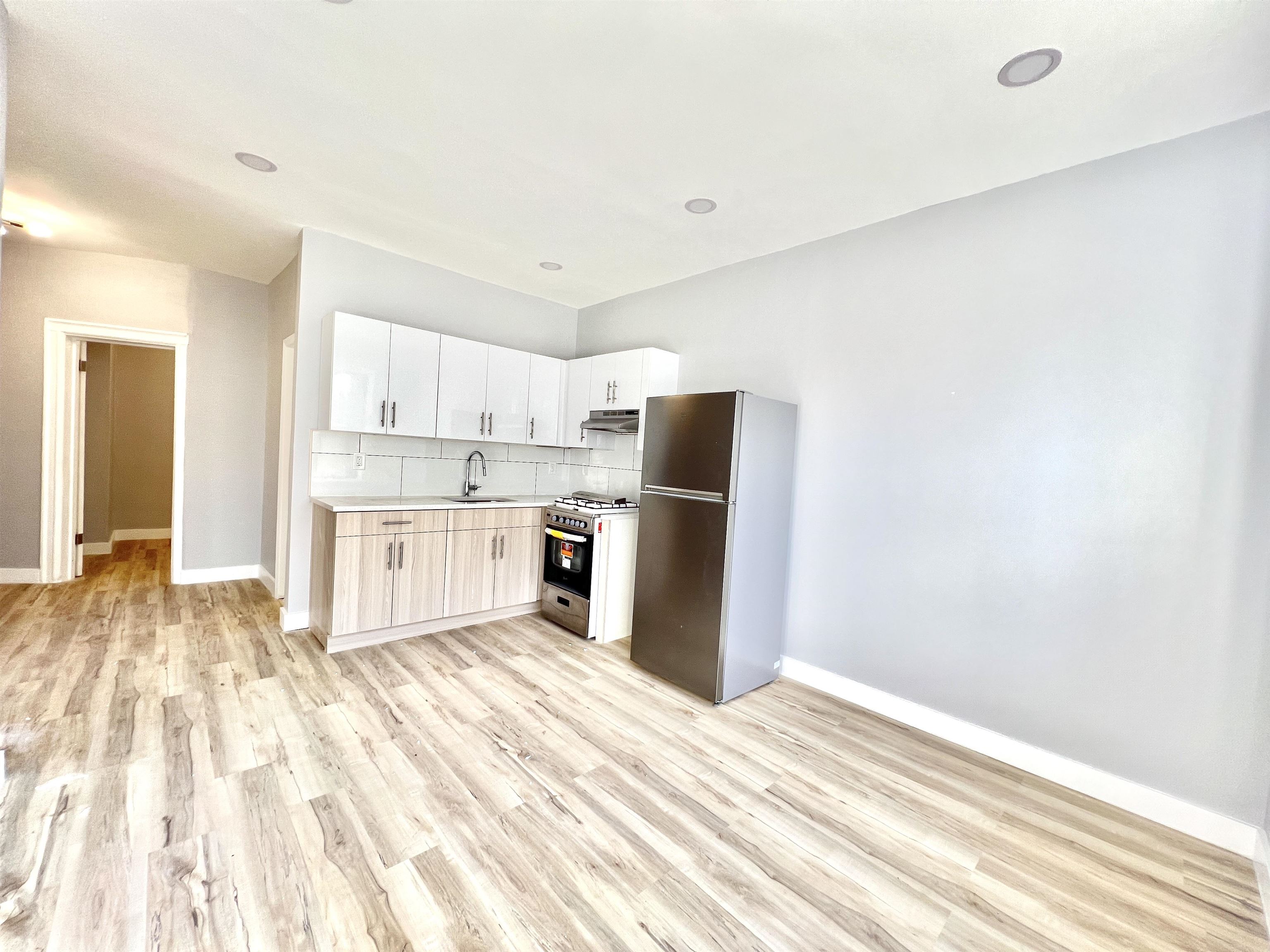 a kitchen with a refrigerator sink and cabinets