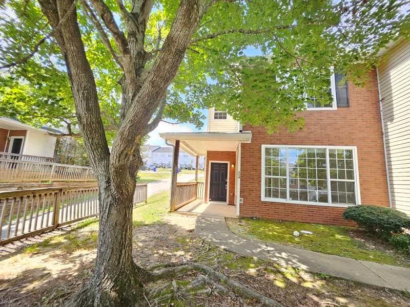 a view of a house with a tree in front of it