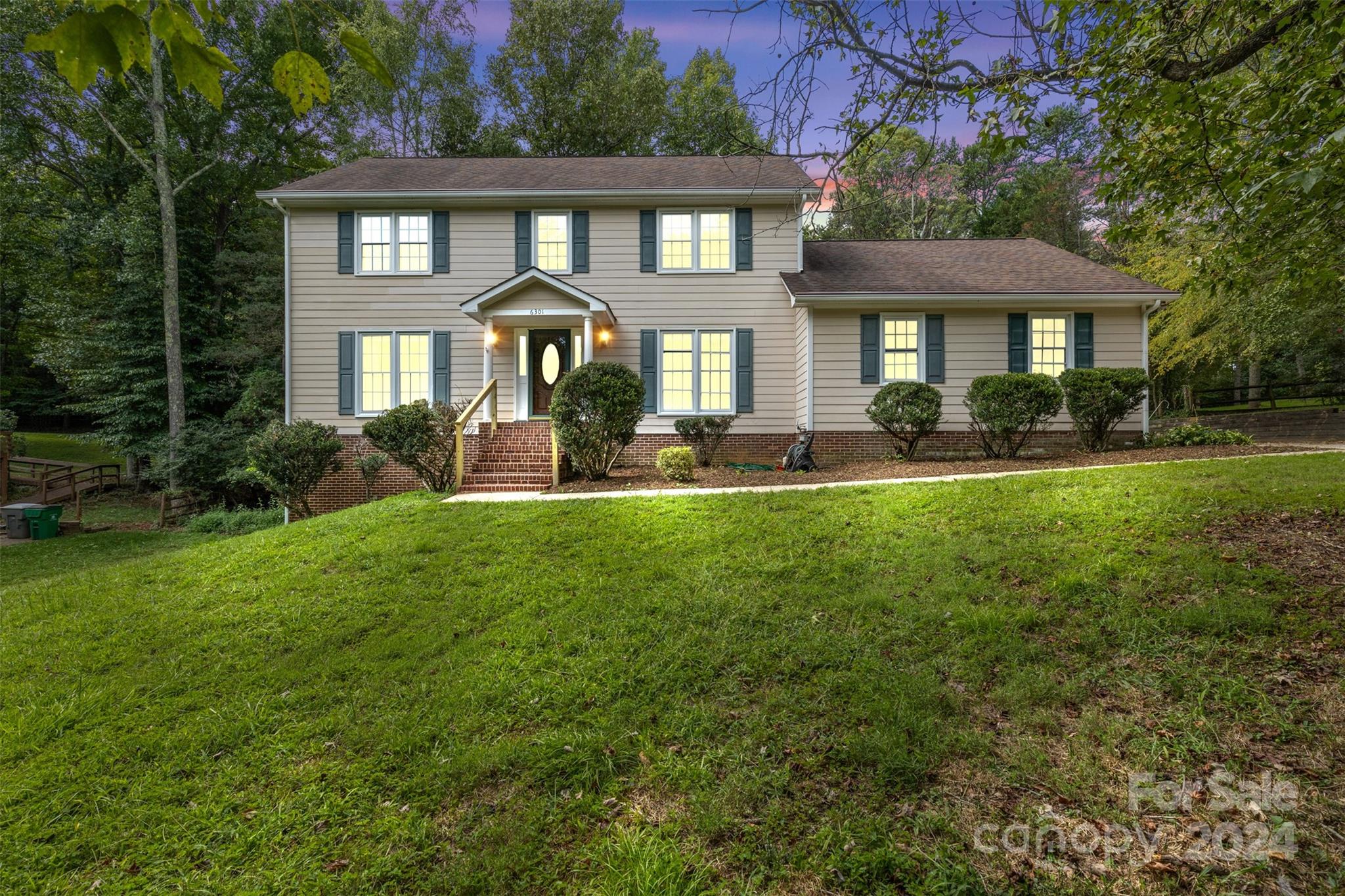 a front view of a house with yard and green space