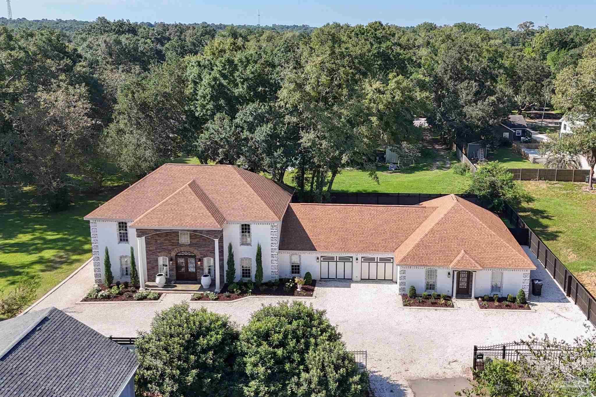 an aerial view of a house with swimming pool and garden