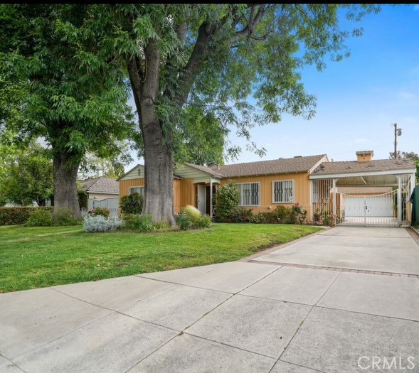 a front view of a house with a yard and trees