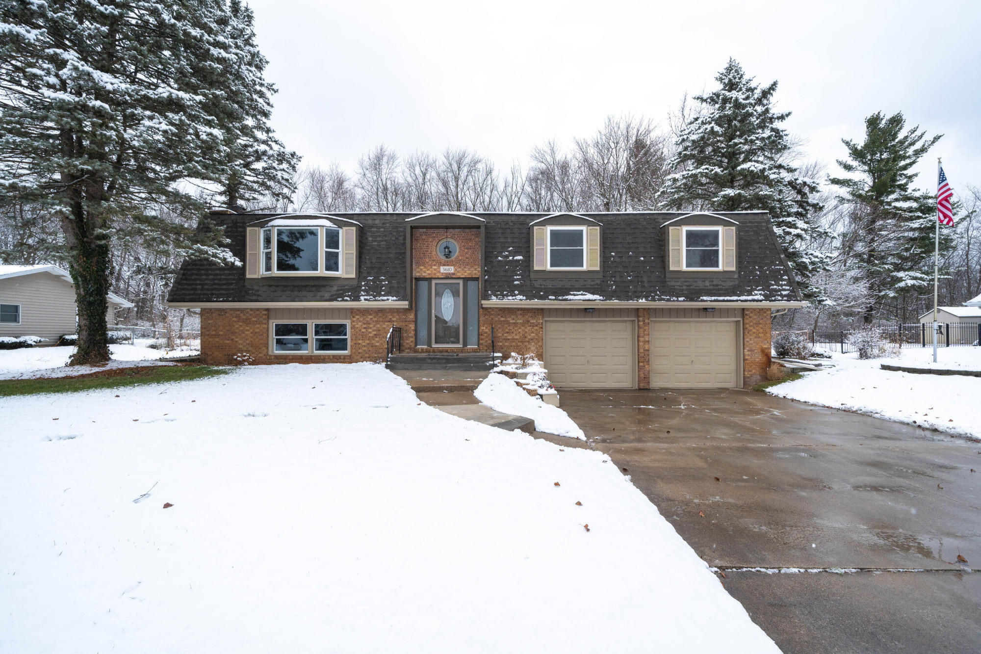 a front view of a house with yard and parking