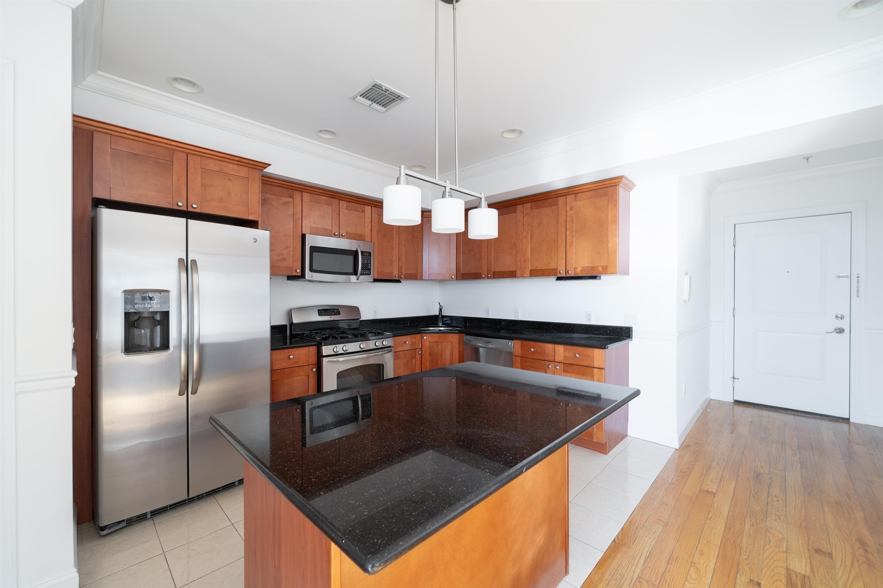 a kitchen with stainless steel appliances granite countertop a sink a stove and a refrigerator