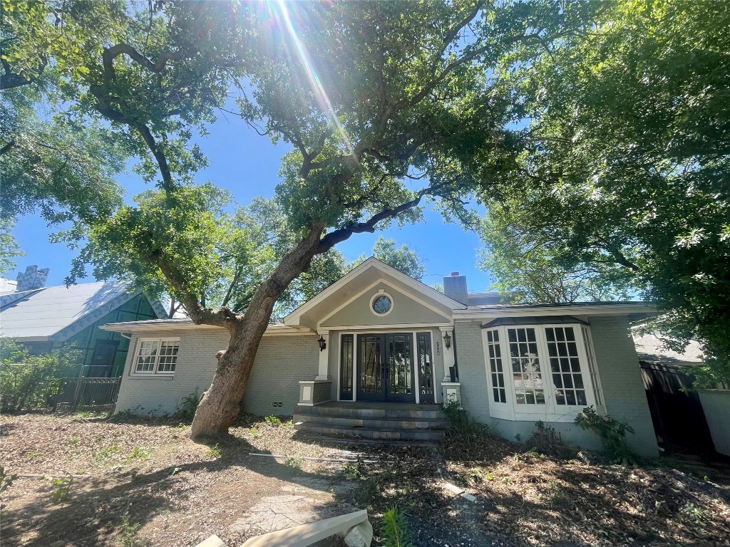 a front view of house with yard and trees around