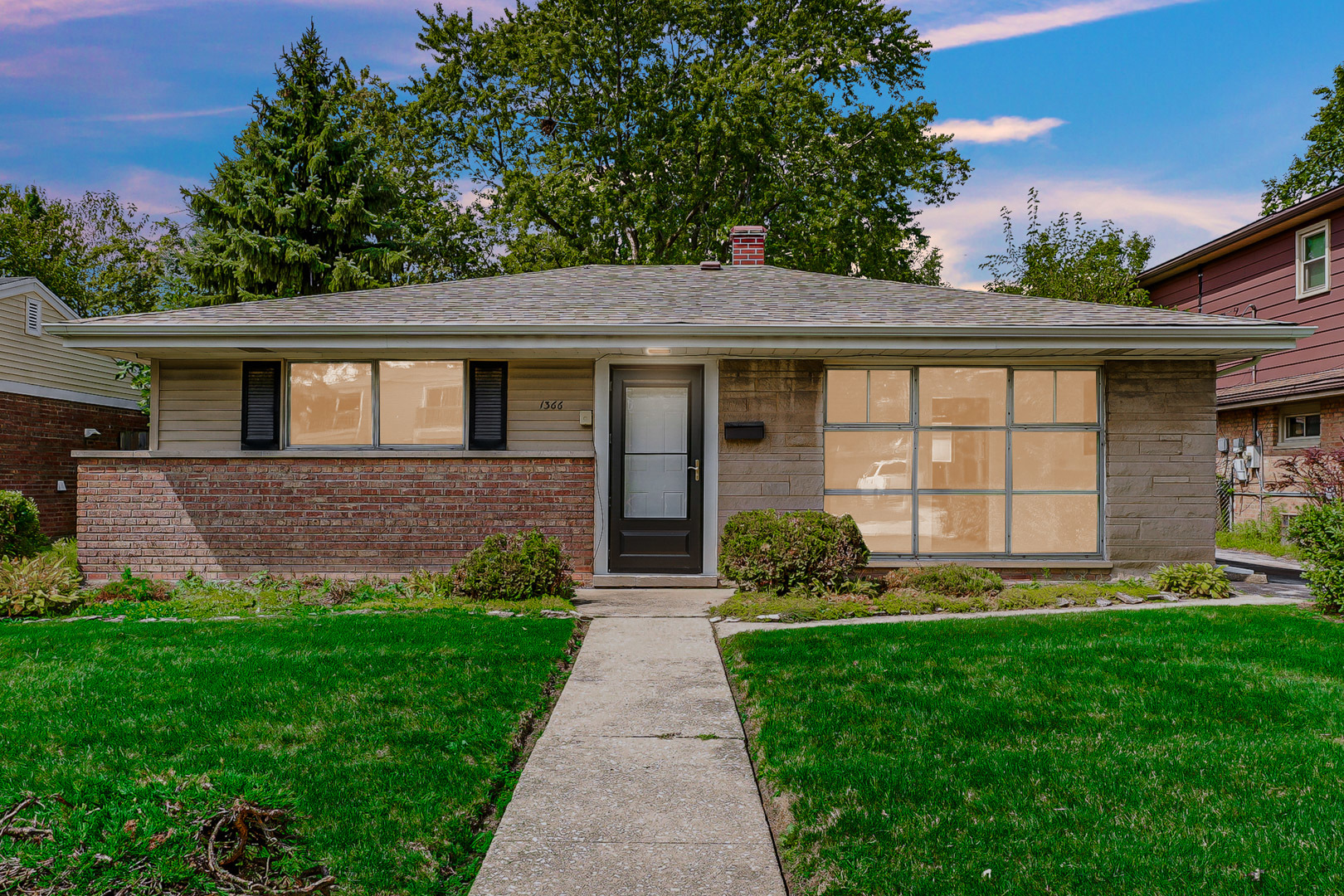 a front view of a house with a yard and outdoor seating