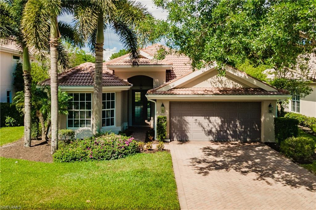 a front view of a house with a garden and trees