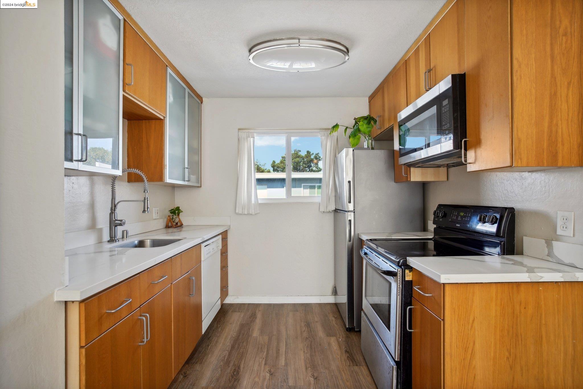 a kitchen with stainless steel appliances granite countertop a sink stove and cabinets