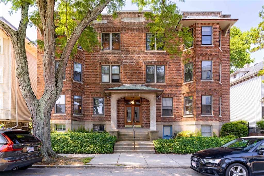 front view of a brick house with a yard