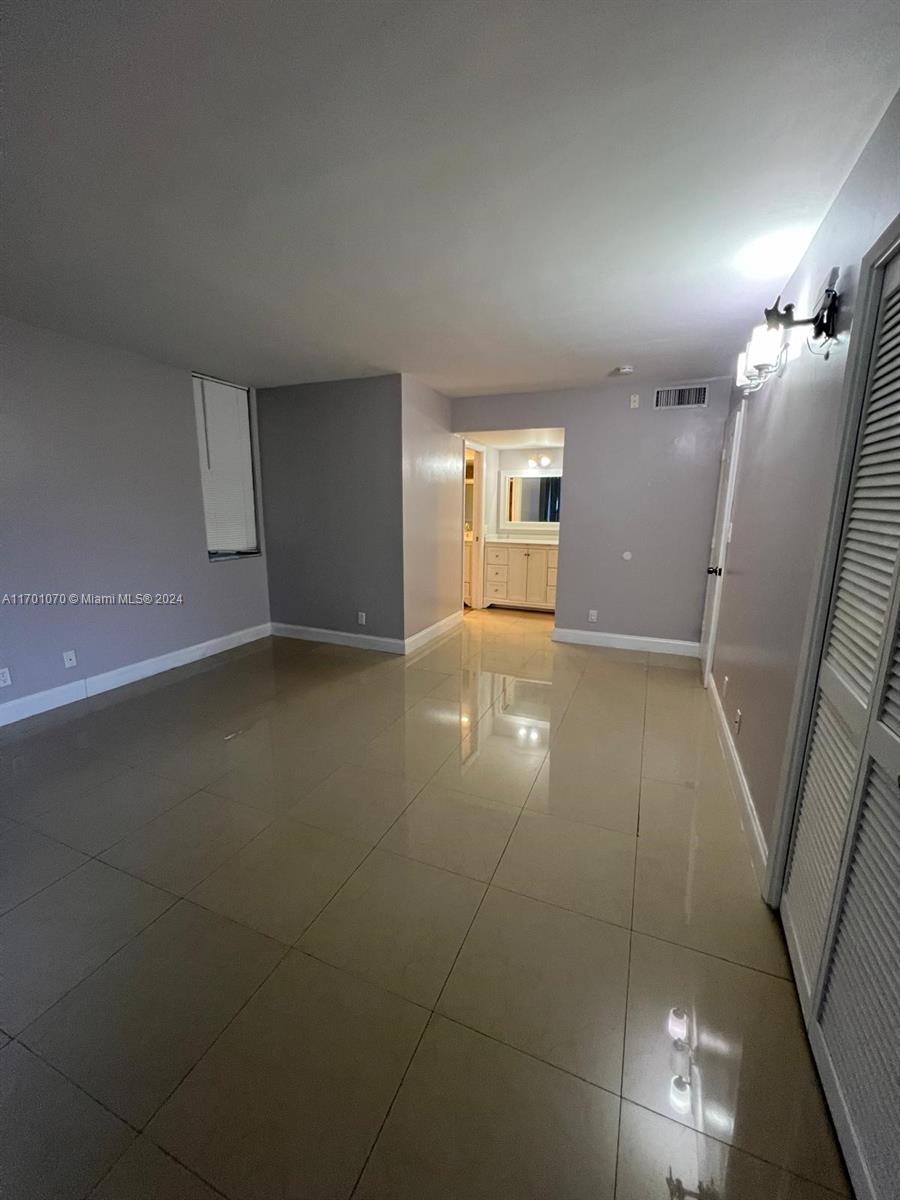 an empty room with stairs and wooden floor