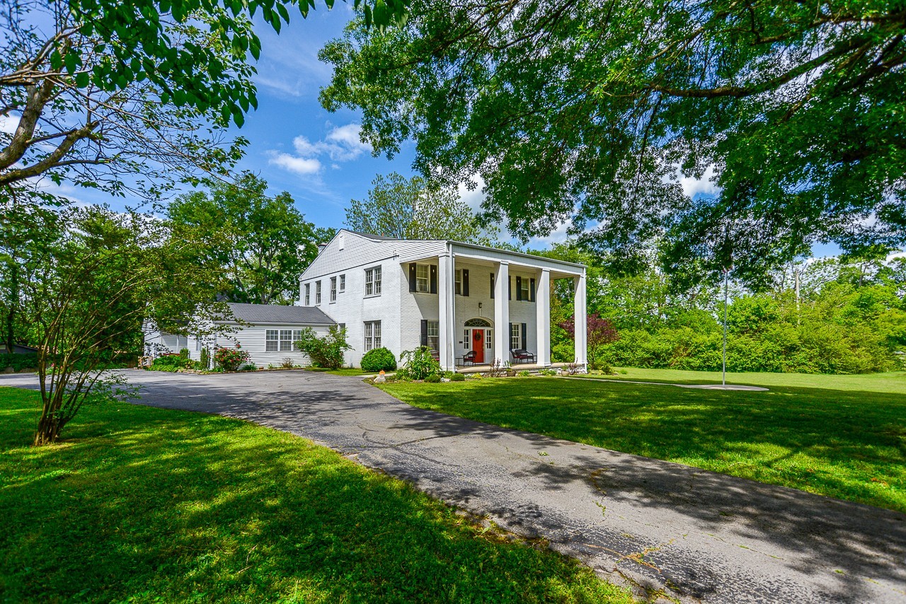 a front view of a house with a yard and trees