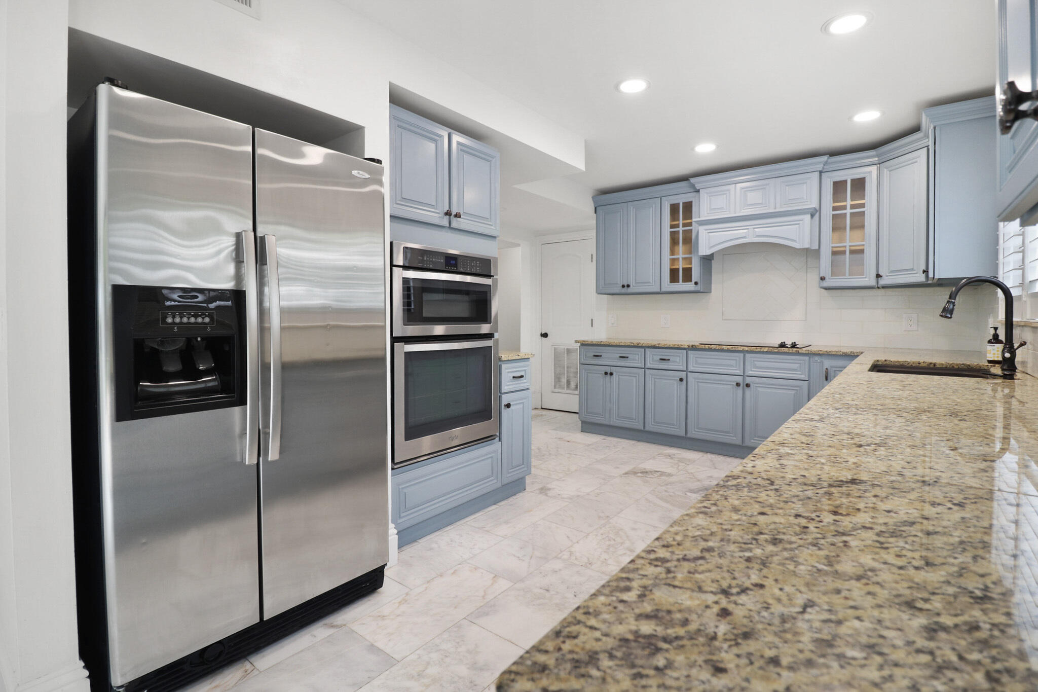 a kitchen with stainless steel appliances granite countertop a refrigerator and a sink