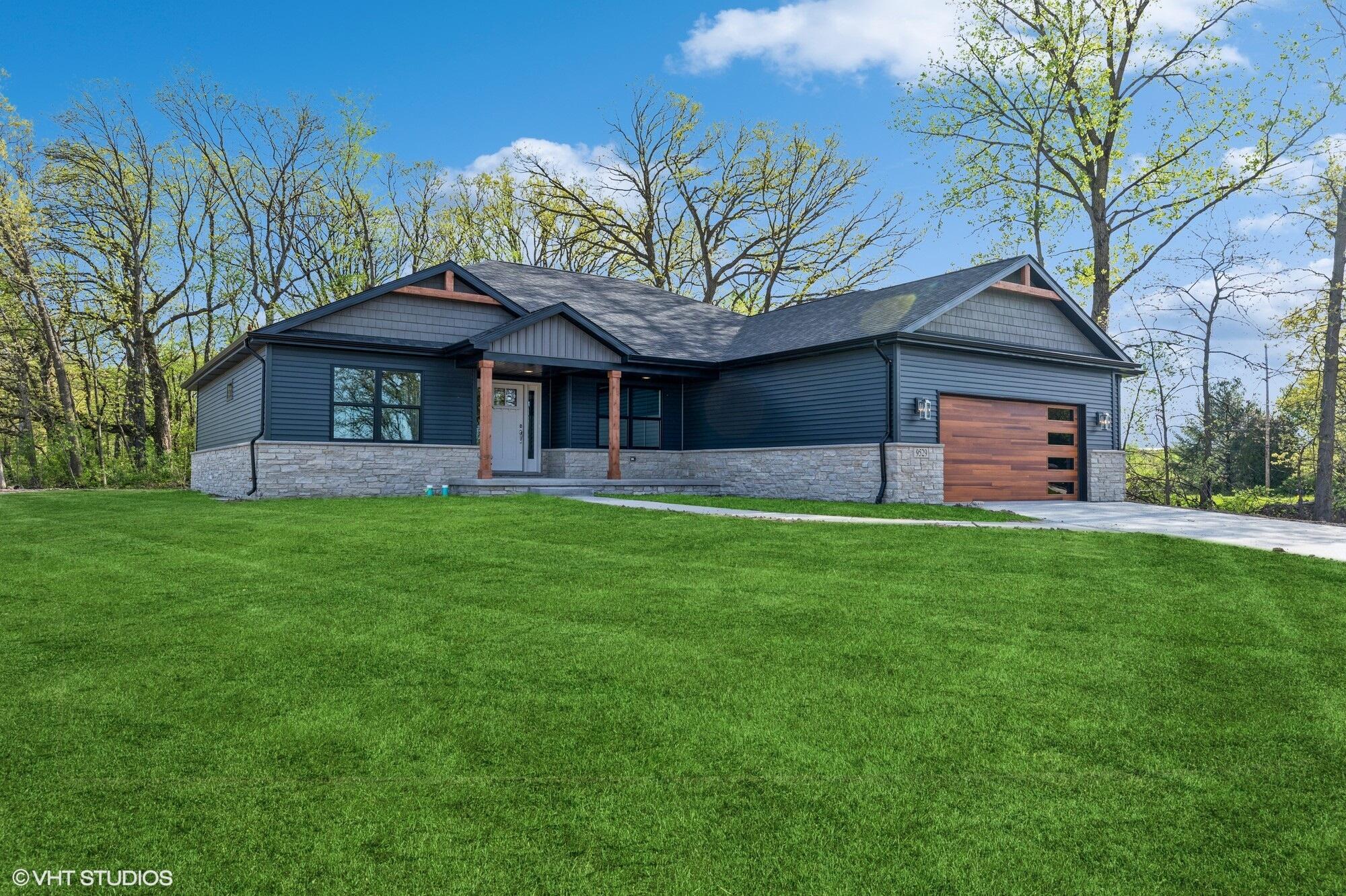 a front view of a house with a garden and plants