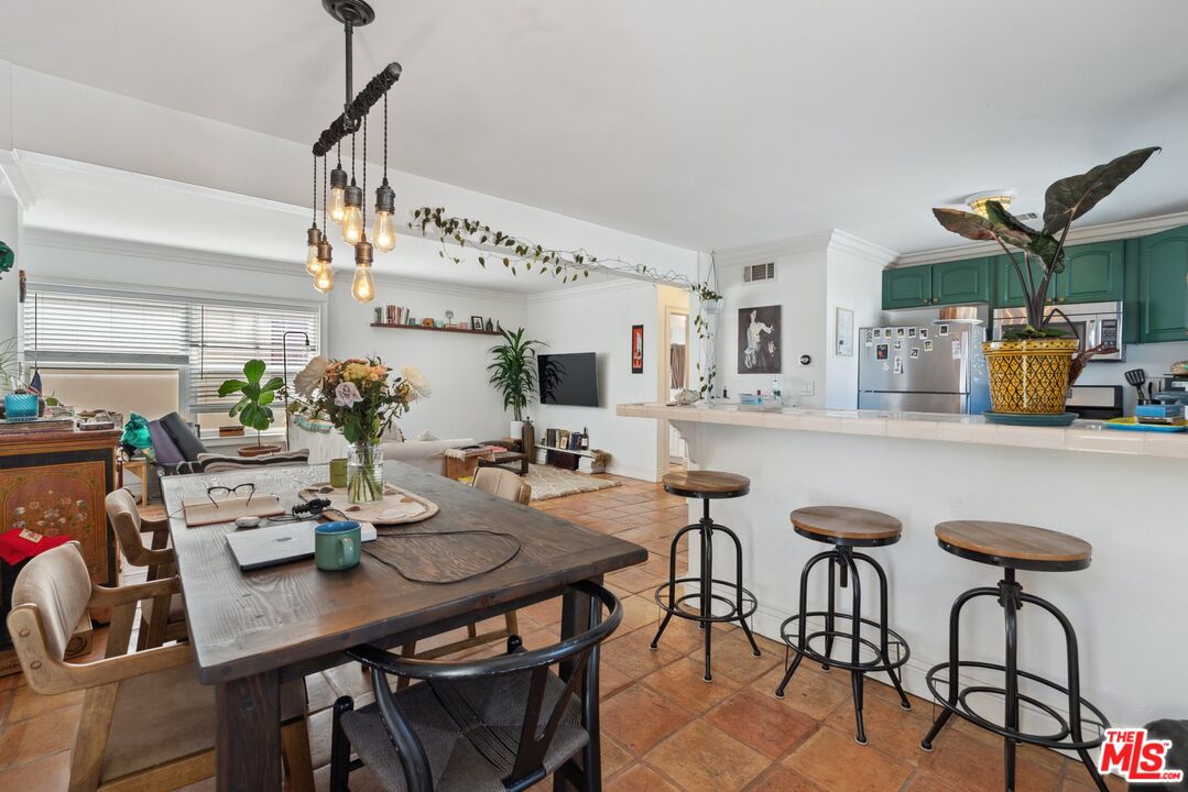 a kitchen with a table chairs and white cabinets