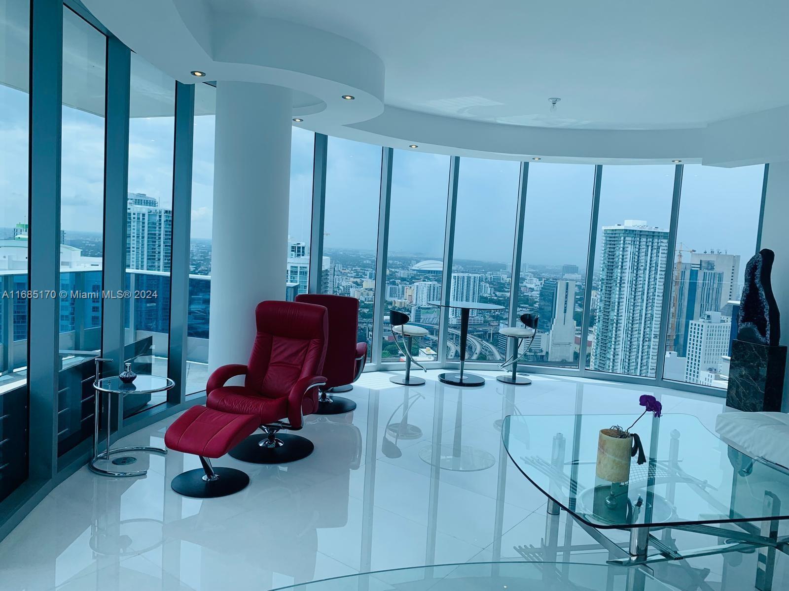 a living room with furniture and large windows