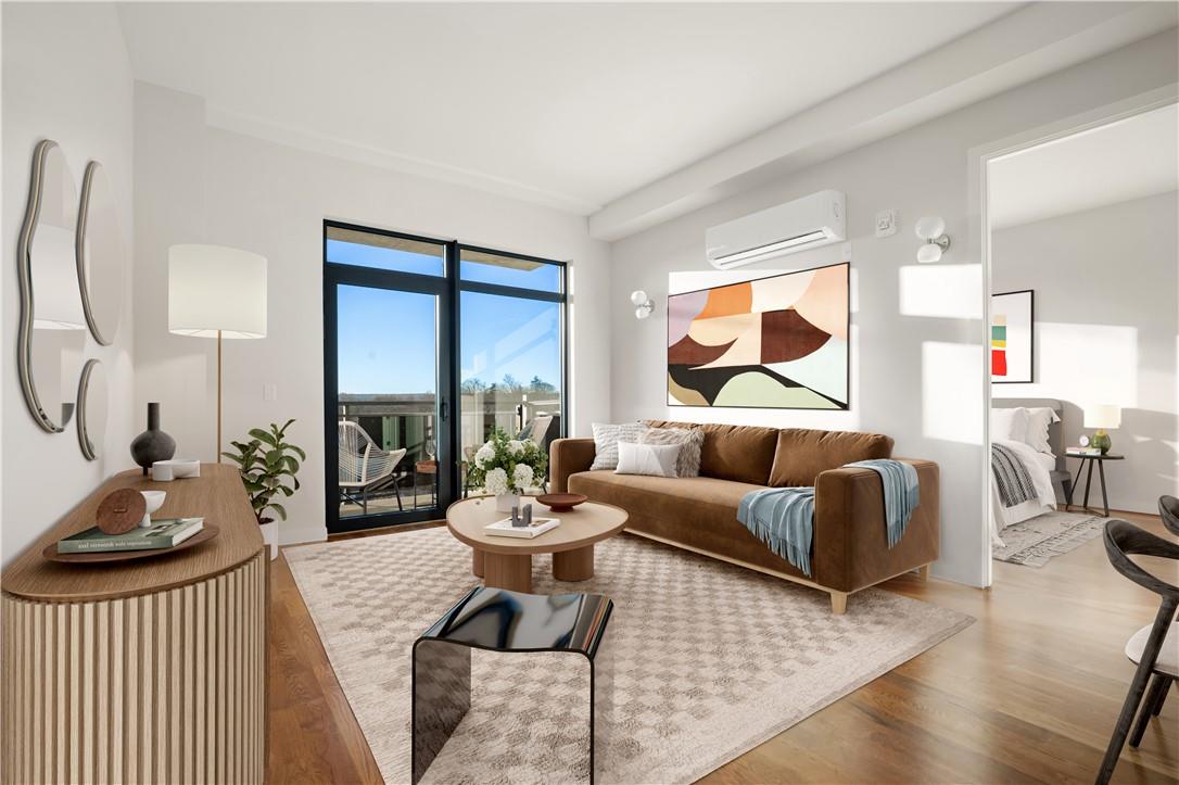 Living room with hardwood / wood-style flooring and a wall mounted air conditioner