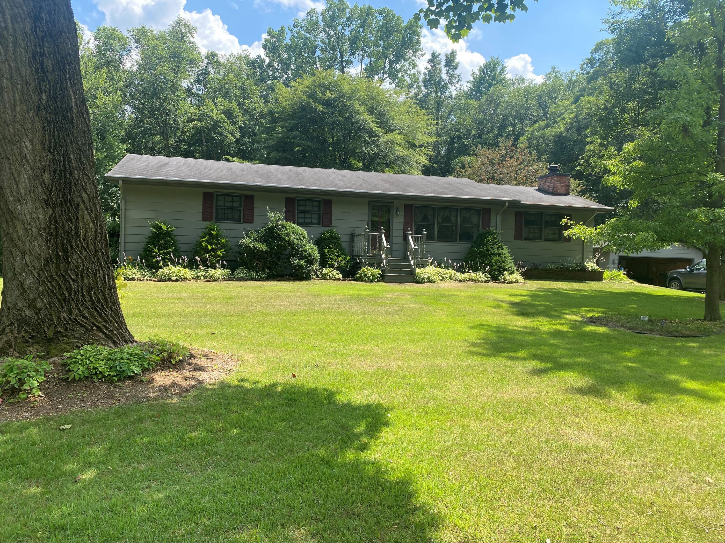 a front view of house with yard and green space