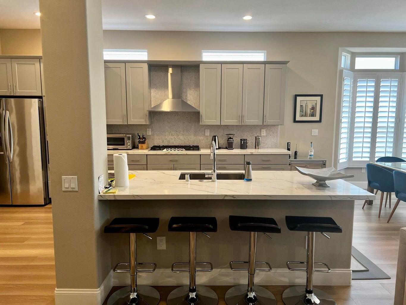 a kitchen with a sink and chairs