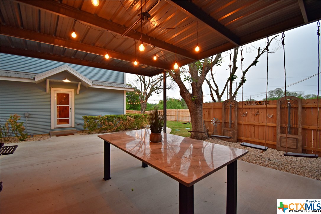 a backyard of a house with barbeque oven table and chairs