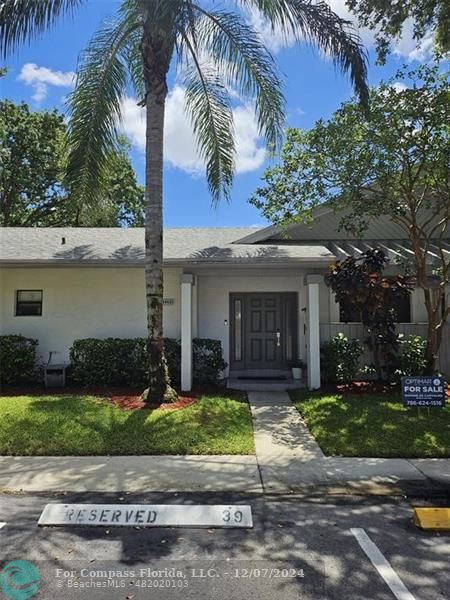 a front view of a house with a yard and potted plants