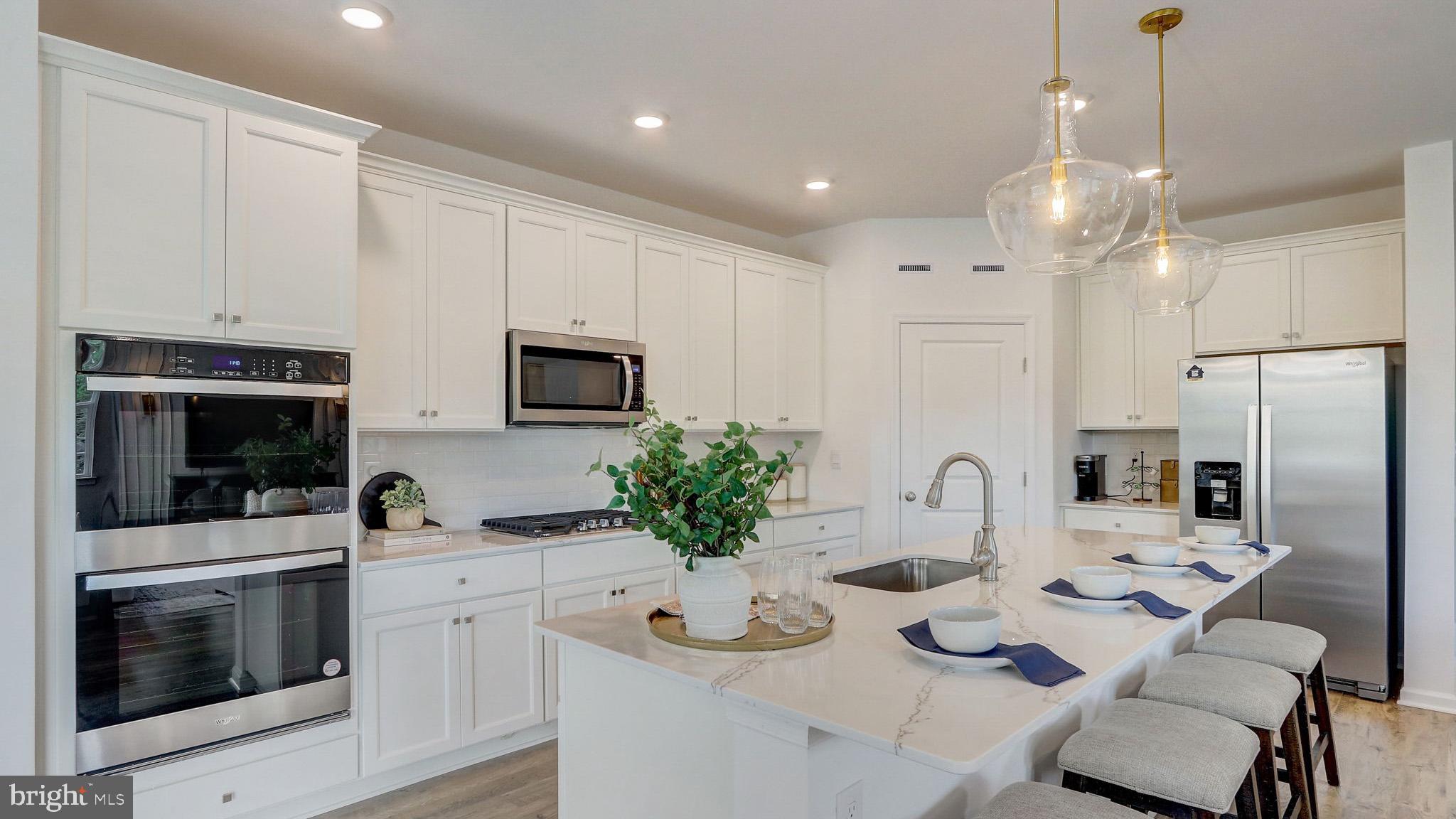 a kitchen with stainless steel appliances kitchen island granite countertop a stove a sink and a refrigerator