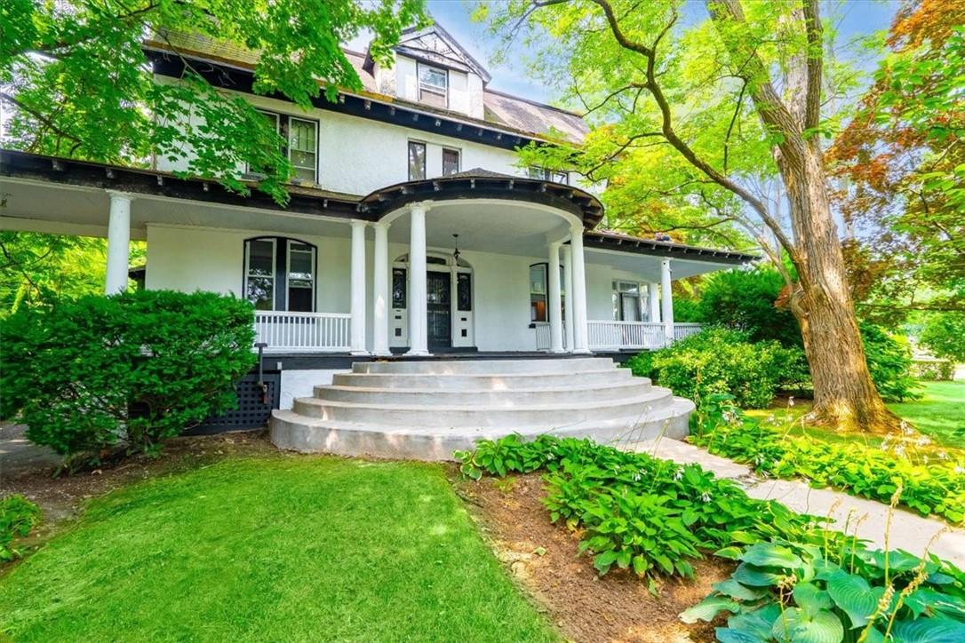 Rear view of house with a yard and covered porch