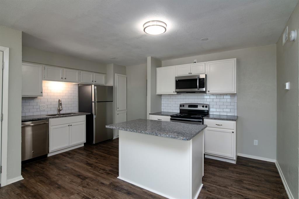 a kitchen with a refrigerator stove and microwave