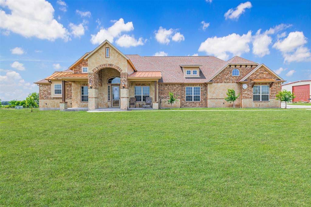 Gorgeous country home featuring a brick and stone elevation located on 36 acres in Brenham, TX.