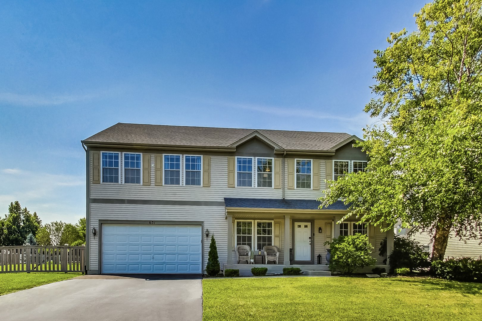 a front view of a house with a yard garage and outdoor seating