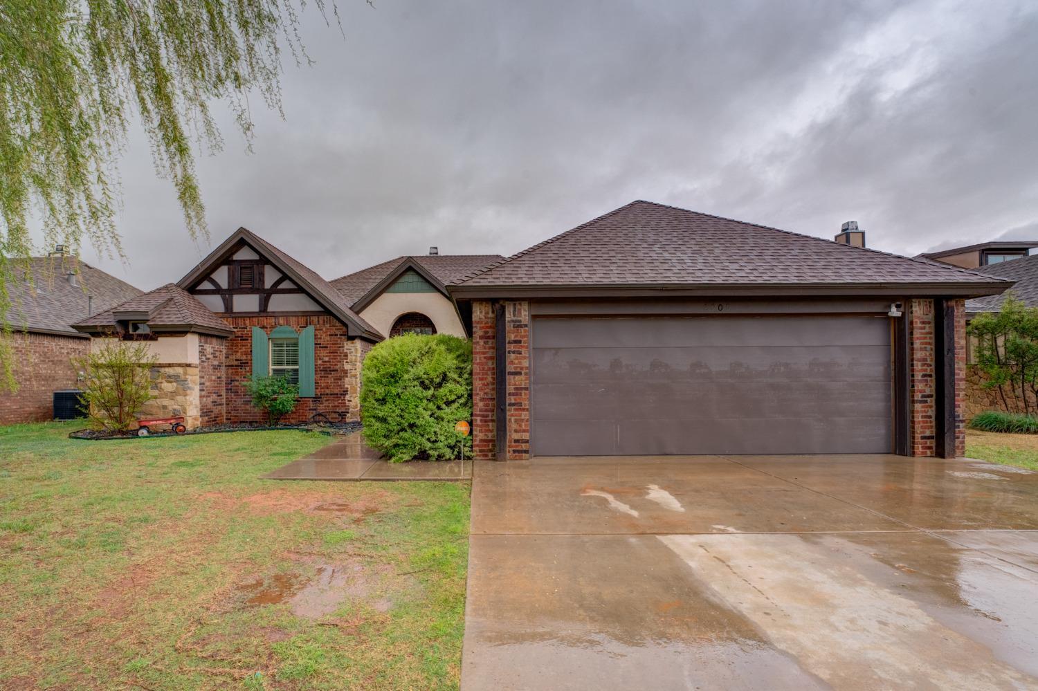 a front view of a house with a garden and garage