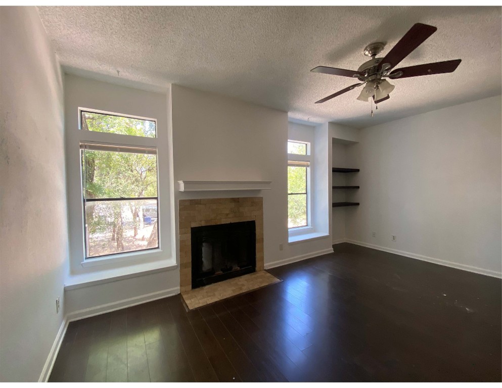 an empty room with windows and fireplace