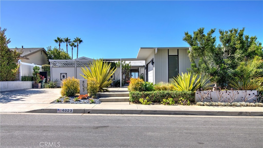 a front view of a house with a garden and patio