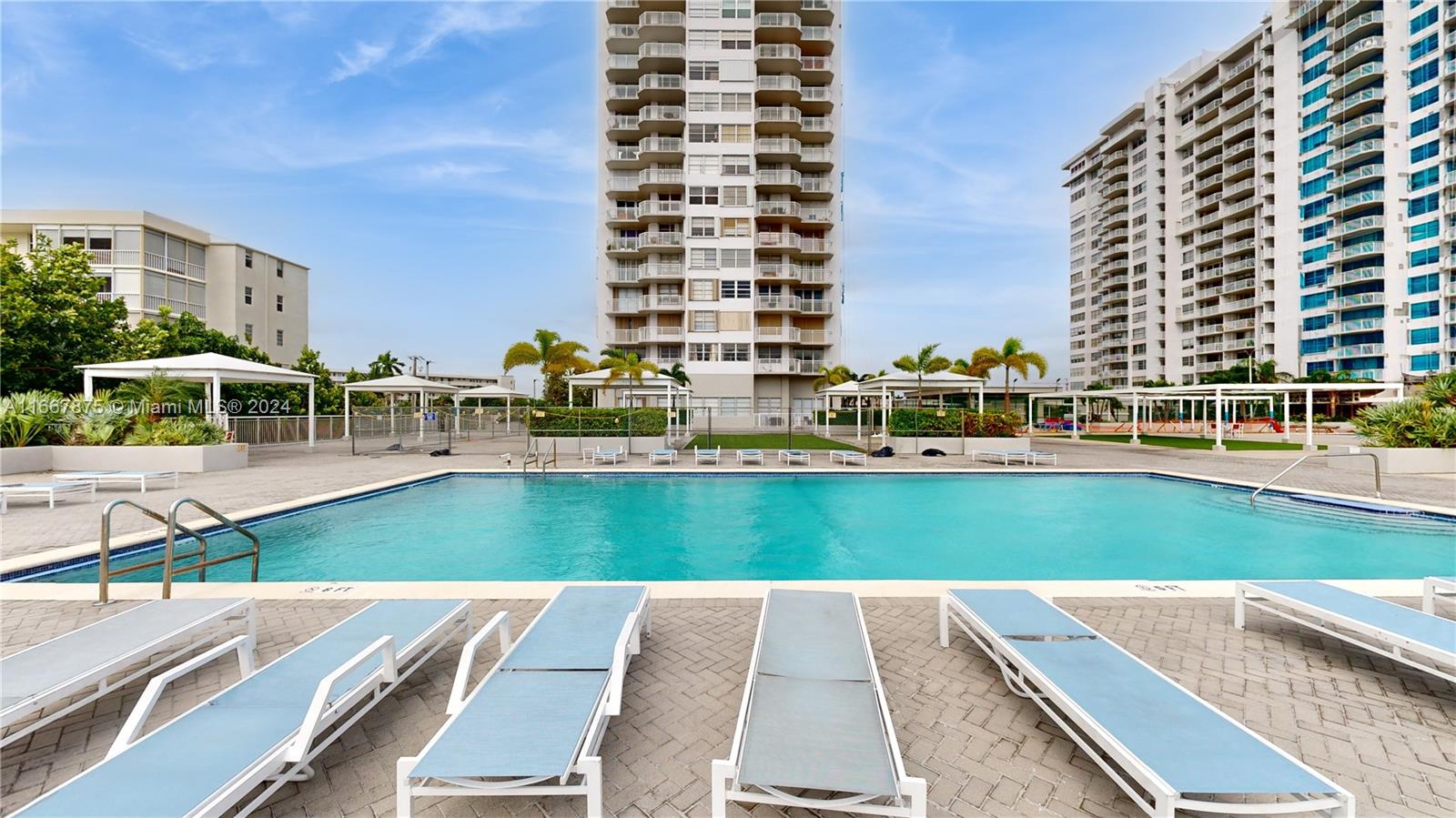 a view of a swimming pool with lawn chairs and a yard