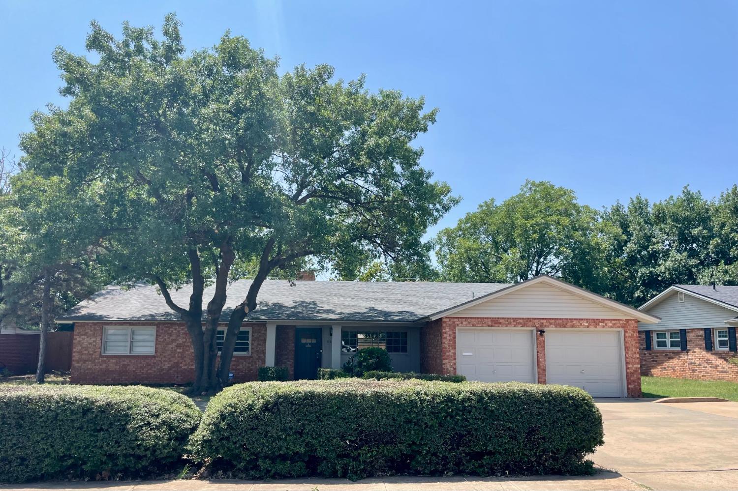 a front view of a house with a yard and trees