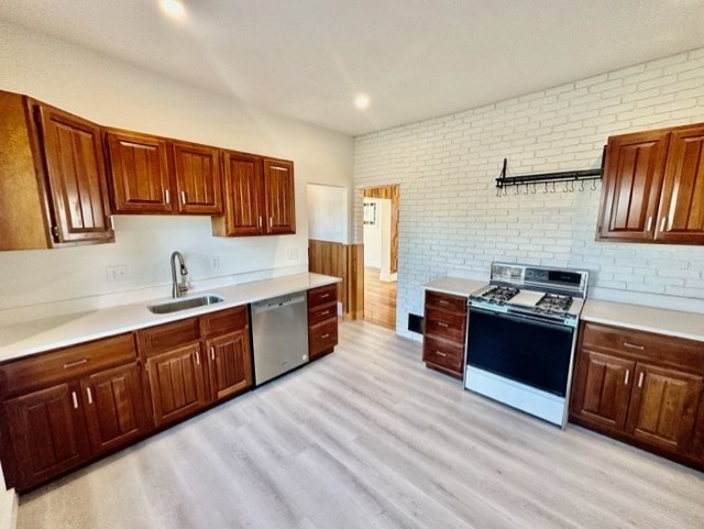 a kitchen with stainless steel appliances granite countertop a sink stove and wooden cabinets