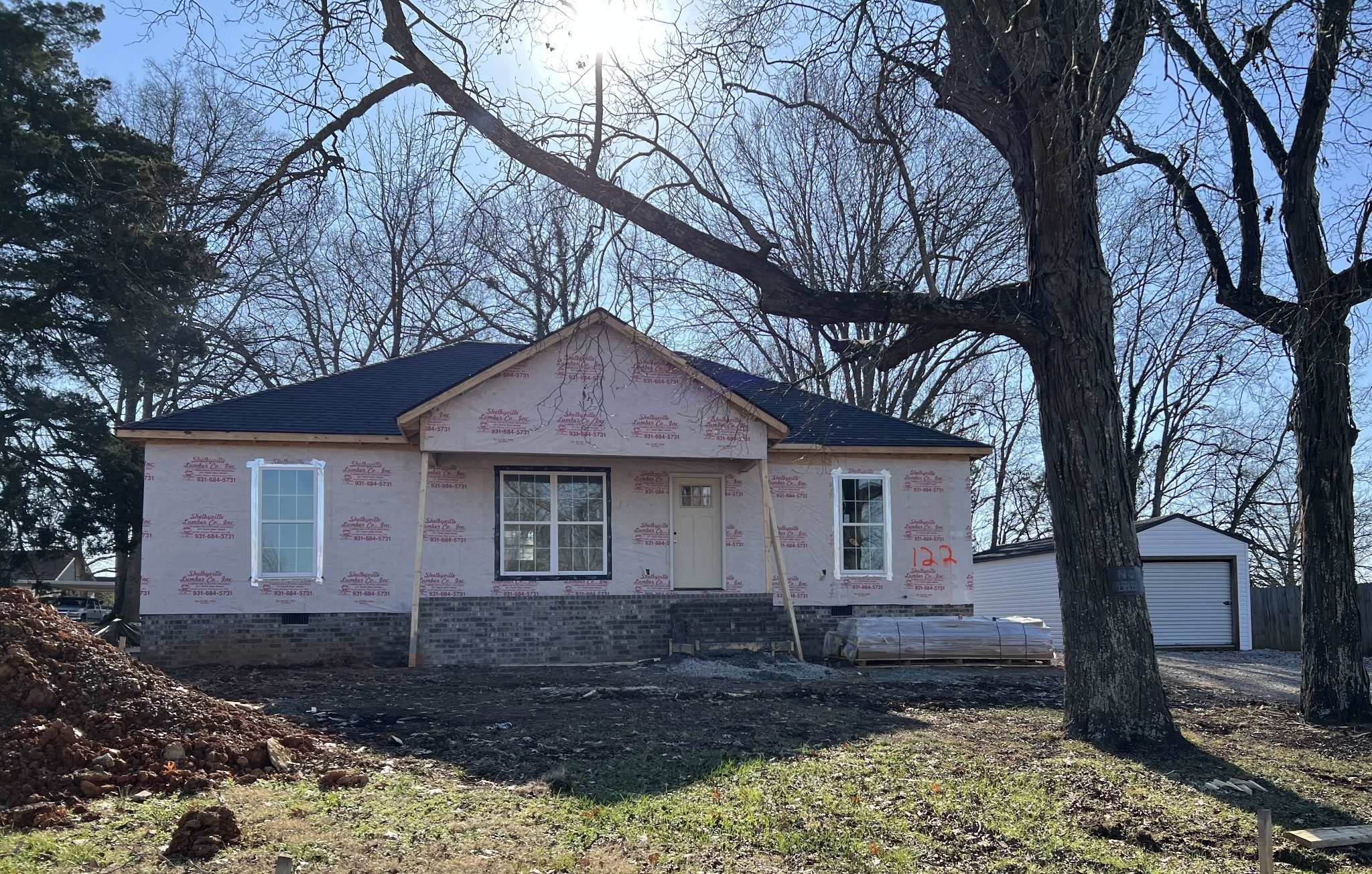 a front view of a house with yard tree