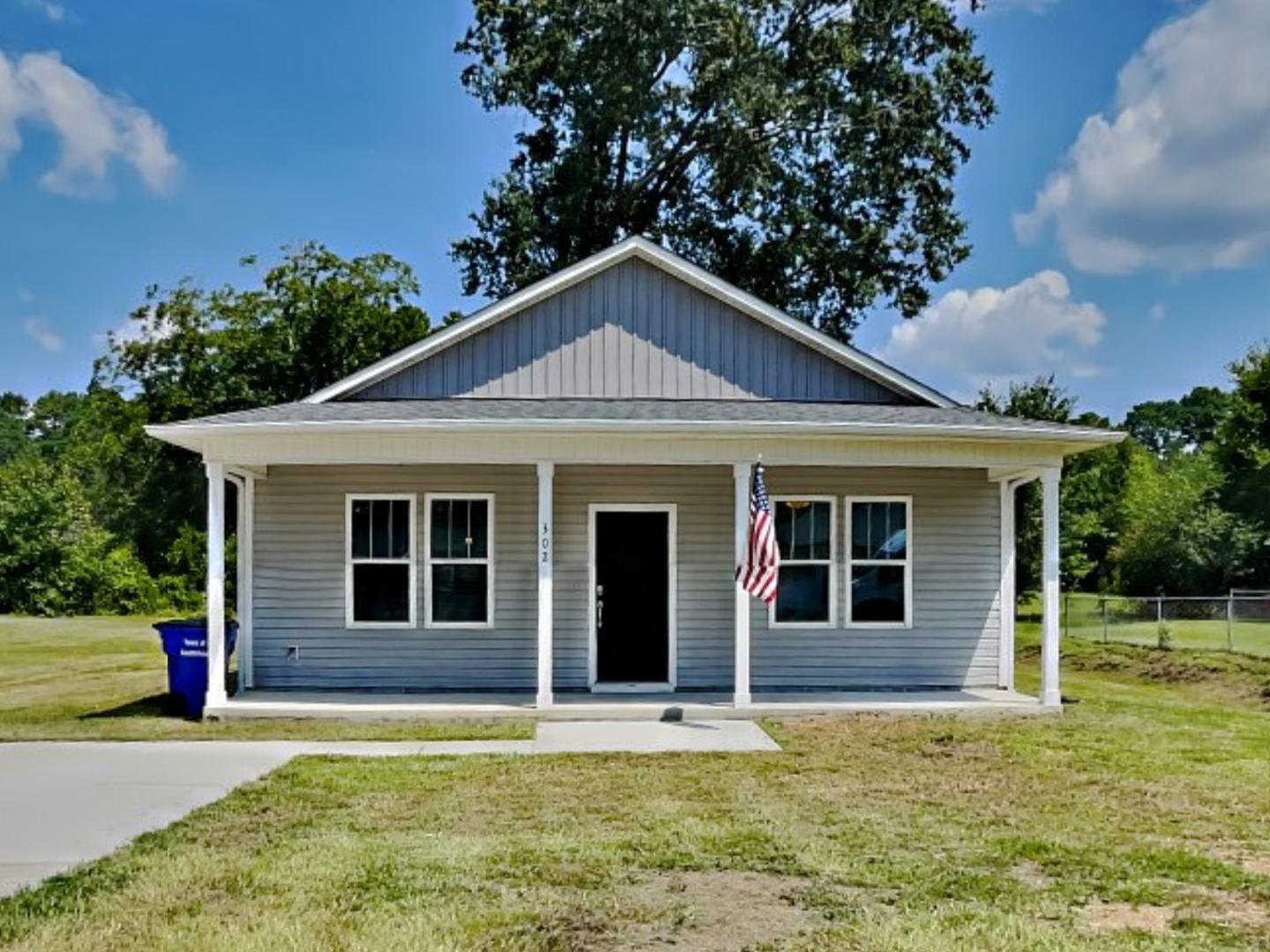 a front view of a house with a garden