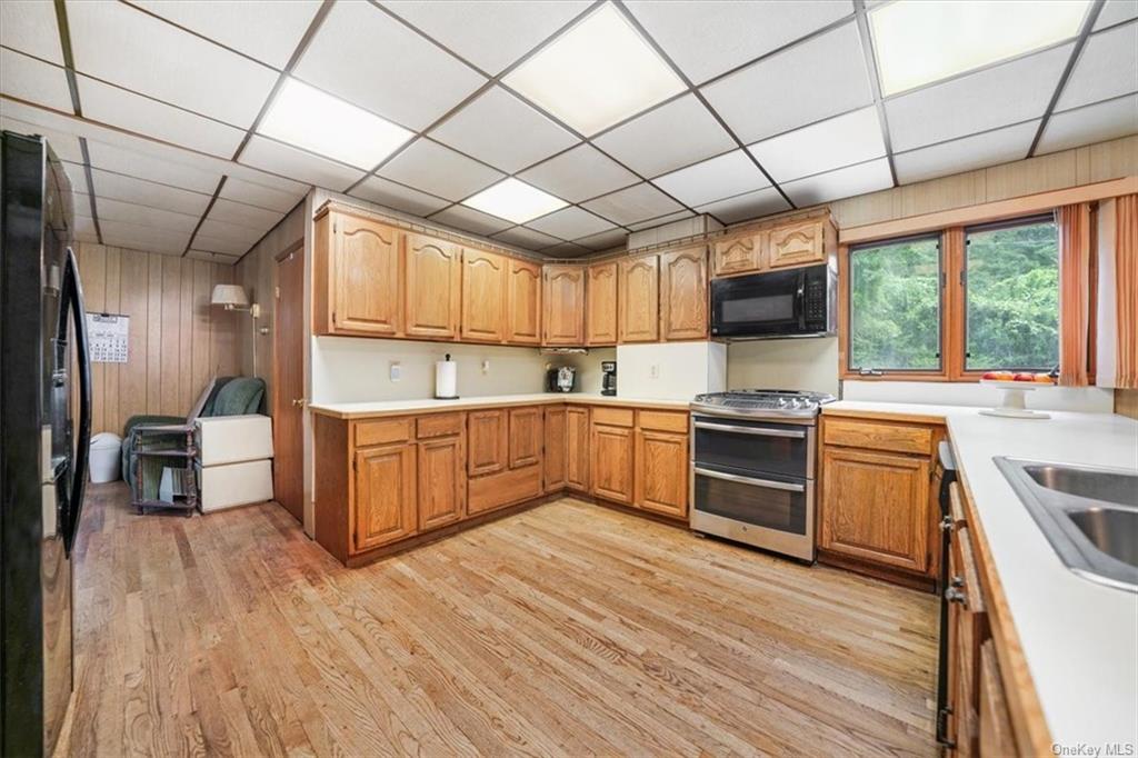 a kitchen with a sink wooden floor and stainless steel appliances