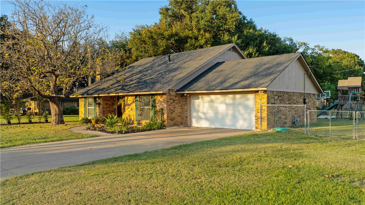 Single story home featuring a front lawn and a gar