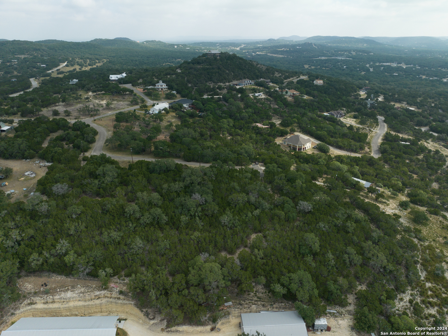 an aerial view of residential houses with outdoor space and trees