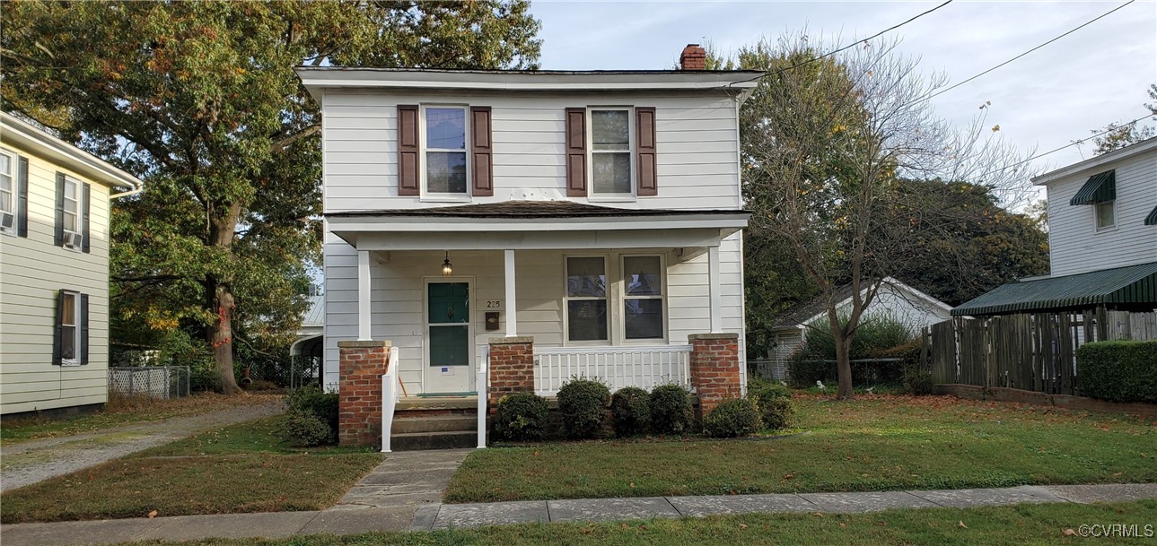 a front view of a house with a yard and trees