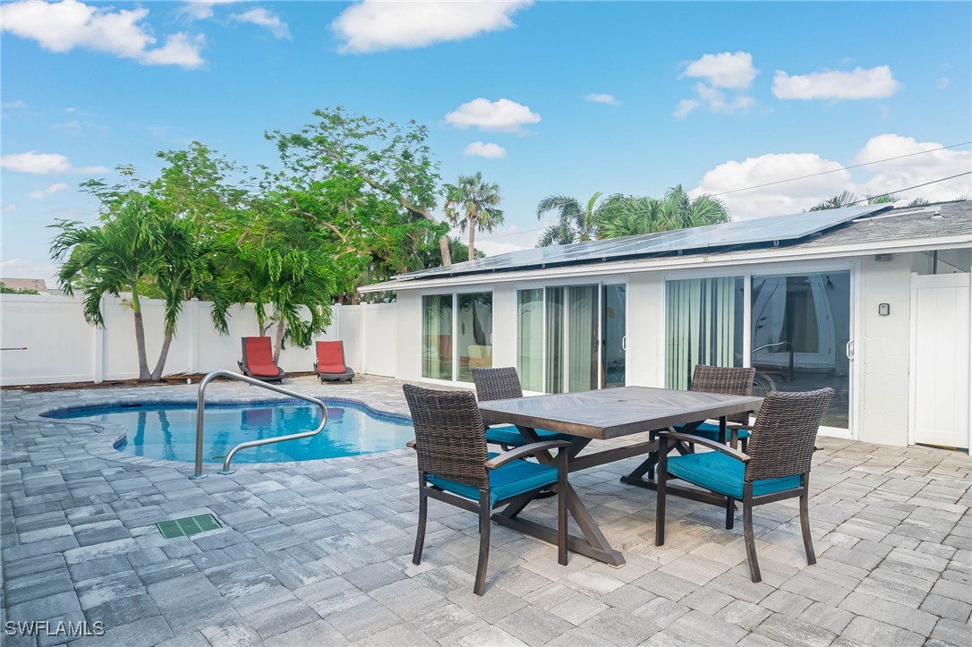 a patio with a table and chairs and potted plants