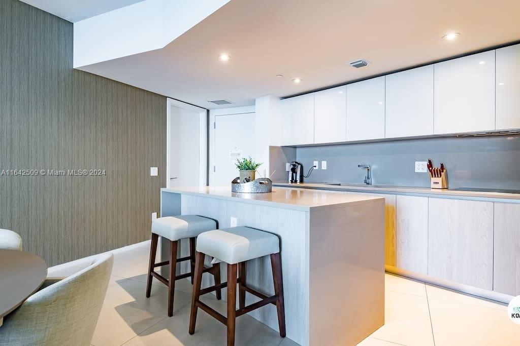 a kitchen with stainless steel appliances granite countertop a sink and a refrigerator