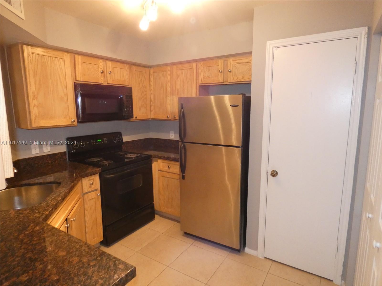 a kitchen with a refrigerator and a stove