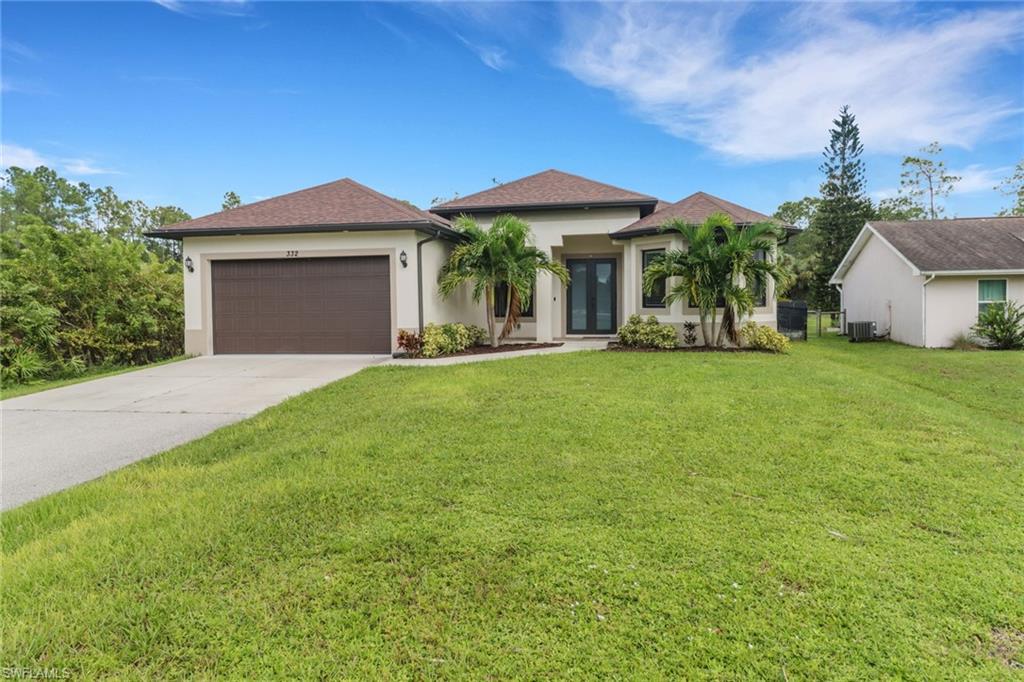 View of front of property with a front yard, a garage, and central air condition unit