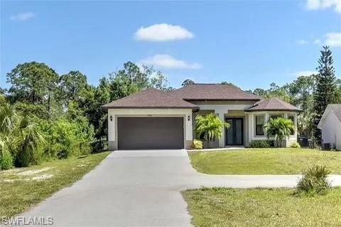 View of front of home with a front lawn and a garage