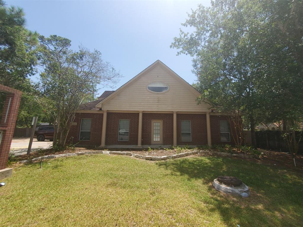 a front view of house with yard and trees in the background