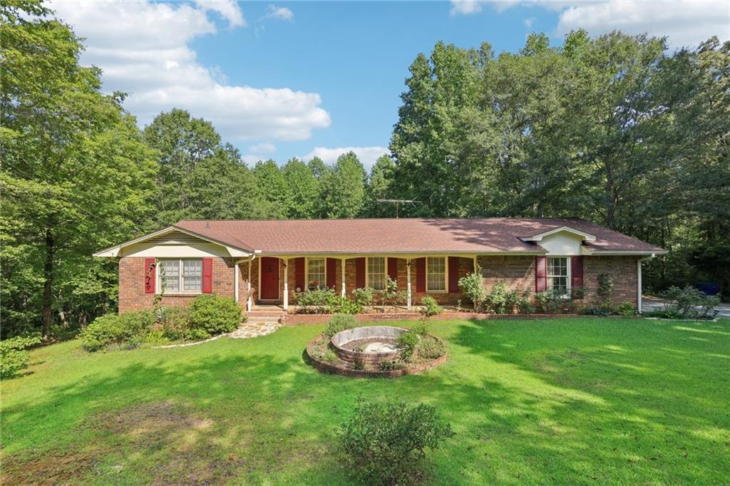 a front view of a house with a garden and trees