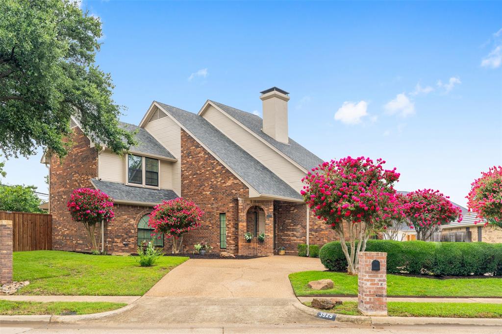 a front view of a house with a yard and potted plants