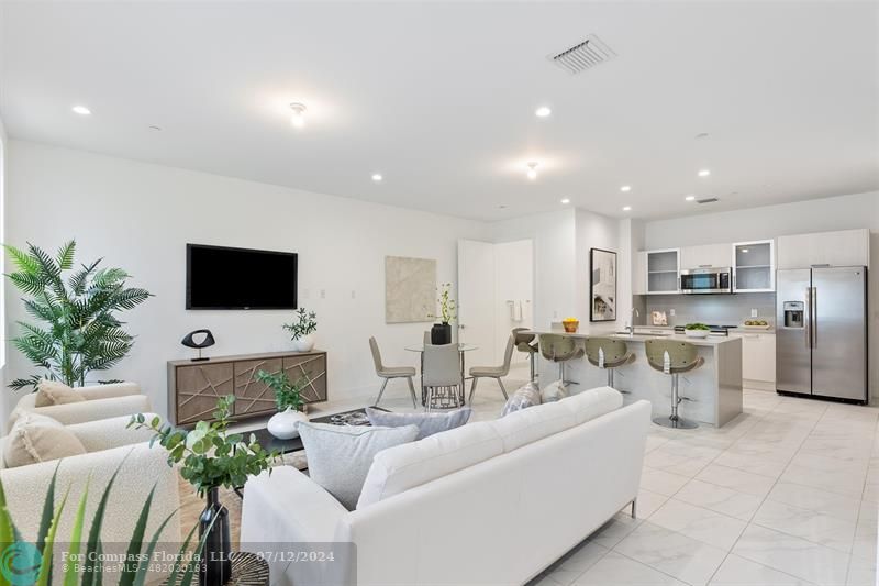 a living room with furniture a flat screen tv and a potted plant