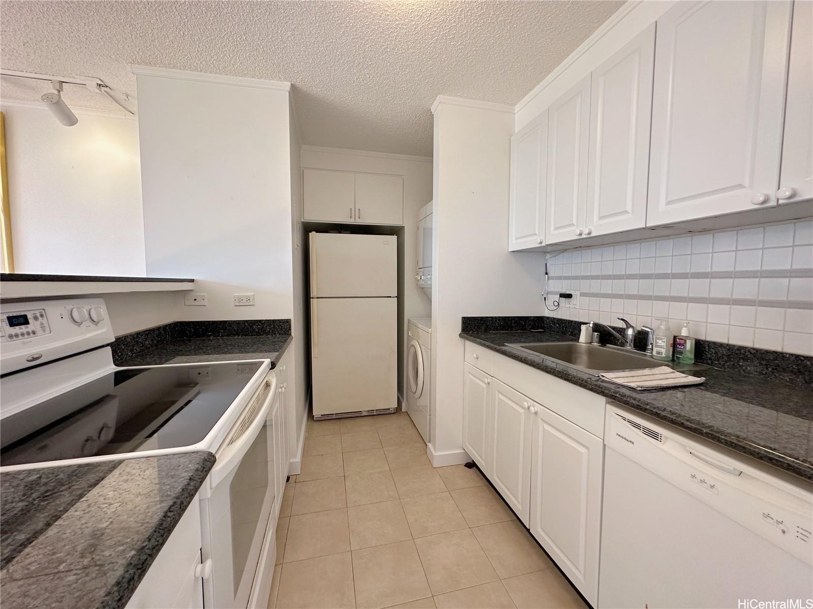 a kitchen with granite countertop white cabinets and stainless steel appliances